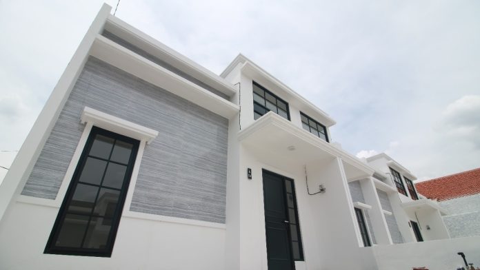 Fasad rumah modern dengan eksplorasi desain bentuk kanopi dan pola garis menggunakan material semen.