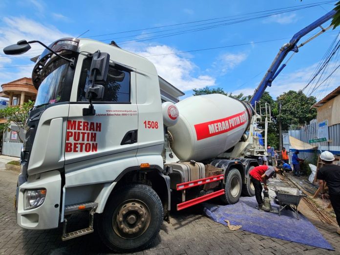 Semen Merah Putih tentang Kekuatan Konstruksi Truk molen atau mixer truck Semen Merah Putih saat di area konstruksi bangunan.