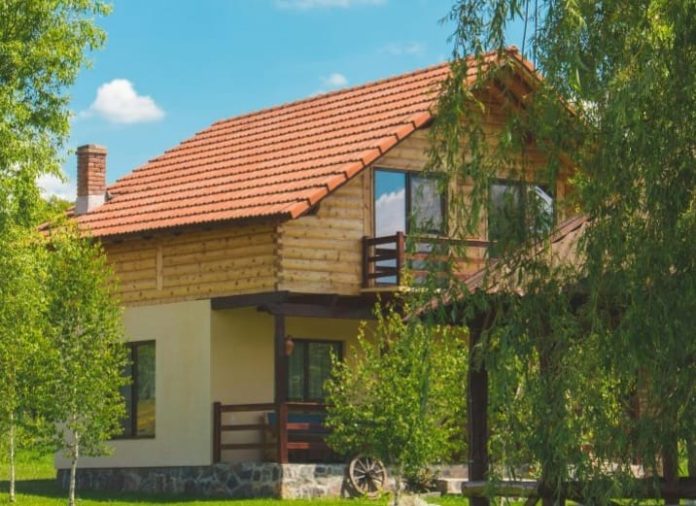 Bangunan rumah dengan dinding tembok dan penggunaan material pengganti kayu sebagai pelapis luar.