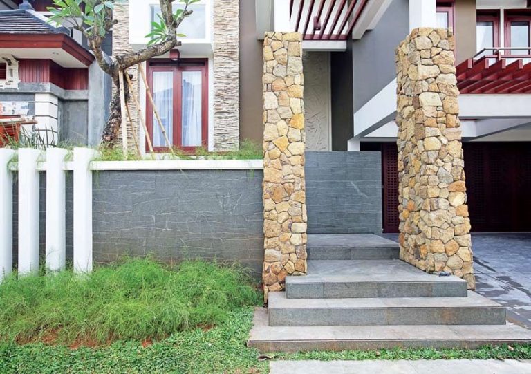 Fasad rumah dengan dua pilar difinshing batu alam.