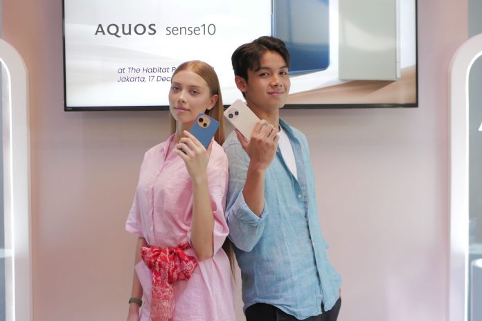 Model menunjukkan smartphone Sharp AQUOS sense10