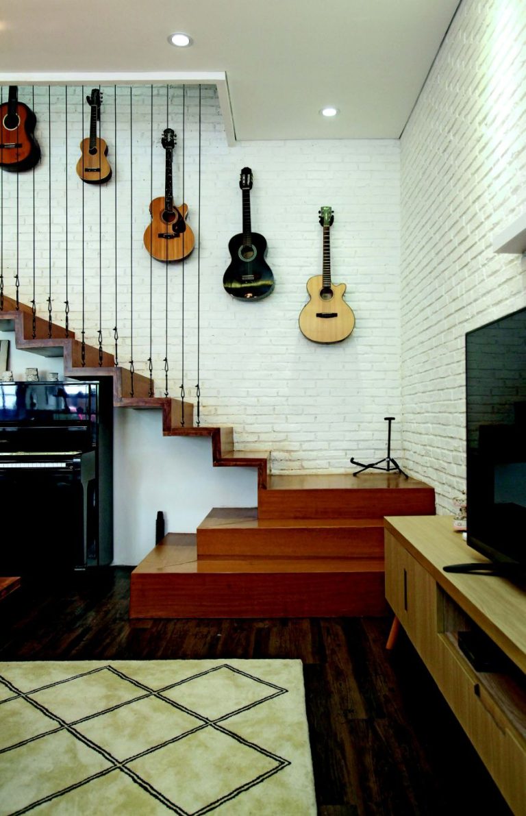 Dinding di area dekat tangga dihias gitar